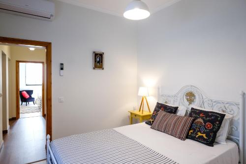 um quarto branco com uma cama branca com almofadas em Casa Séqua em Tavira
