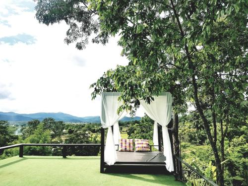 a bed on a deck with a view of the mountains at Chang Pai Hill in Pai