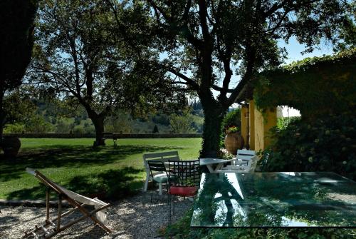 a glass table and chairs in a yard at I Parigi Corbinelli Residenze in Florence