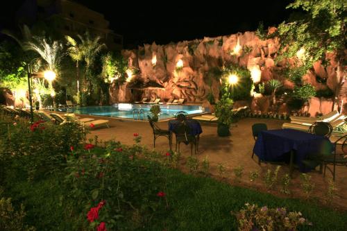 a patio with a table and chairs in front of a pool at Imperial Holiday Hôtel & spa in Marrakech