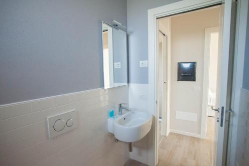 a white bathroom with a sink and a mirror at Italianflat - Maison du Lac in Lazise