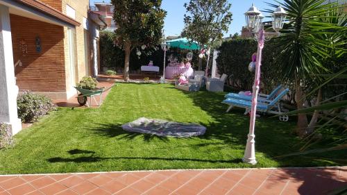 a lawn with a lamp and a blue bench at Maison Tizi in Passoscuro
