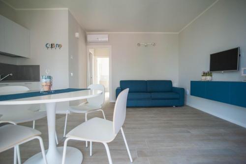 a living room with a table and chairs and a blue couch at Italianflat - Maison du Lac in Lazise