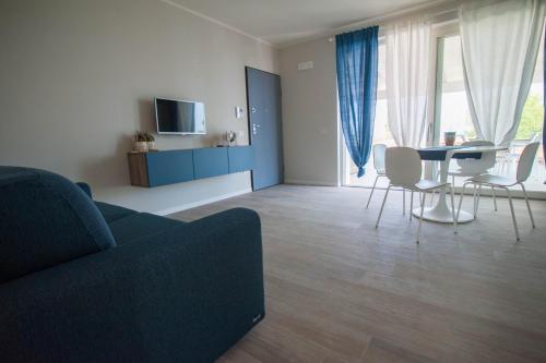 a living room with a couch and a table and chairs at Italianflat - Maison du Lac in Lazise