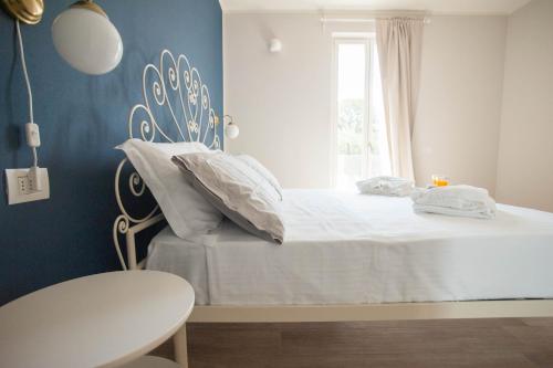 a bedroom with a bed with white sheets and a window at Italianflat - Maison du Lac in Lazise