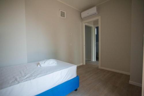 a bedroom with a white bed and a hallway at Italianflat - Maison du Lac in Lazise