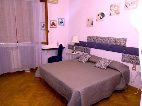 una camera con un letto e una sedia e una finestra di MEL Affittacamere a Firenze