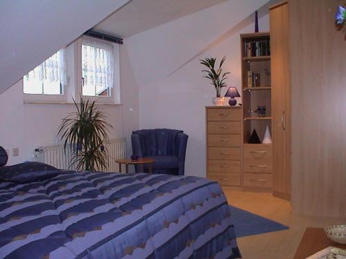 a bedroom with a bed and a dresser and a window at Fewo "Habichtswald" in Niedenstein