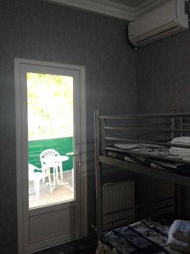 a bedroom with a bunk bed and a window and a table at Nika7 in Tbilisi City