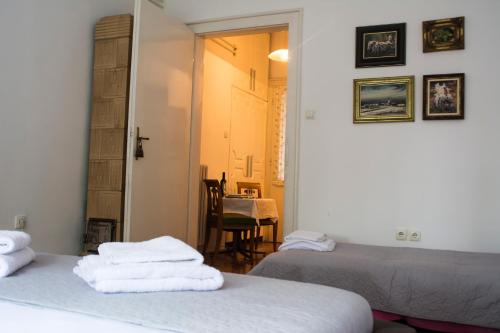 a room with two beds and a dining room with a table at Dunavski Park in Novi Sad