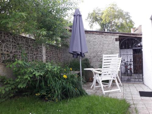 an umbrella and two chairs in a garden at Villa Nusswald in Krumpendorf am Wörthersee