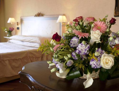 a vase of flowers on a table in a bedroom at Punta Campanella Resort & Spa in Massa Lubrense