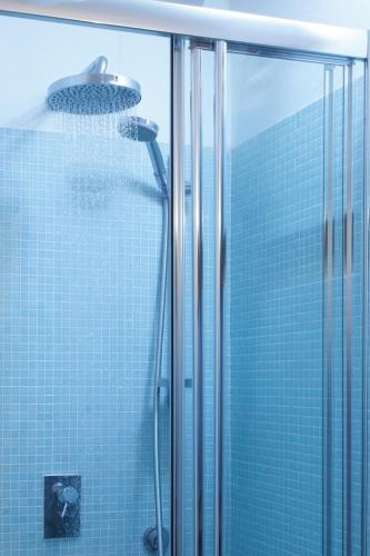a shower with a shower head and a glass door at CampuSpace in Cagliari