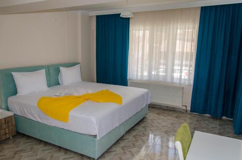 a bedroom with a bed with a yellow blanket on it at Çanakkale Venüs Pansiyon in Canakkale