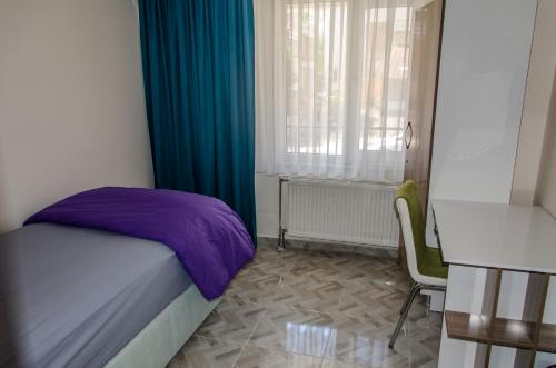 a bedroom with a bed and a desk and a window at Çanakkale Venüs Pansiyon in Canakkale