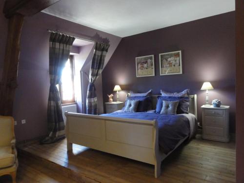 - une chambre avec un lit doté de draps bleus et d'oreillers bleus dans l'établissement Le Manoir des Tuileries, à Rouffilhac