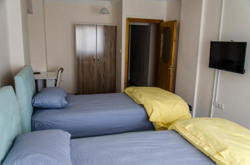 a bedroom with two beds and a flat screen tv at Çanakkale Venüs Pansiyon in Canakkale