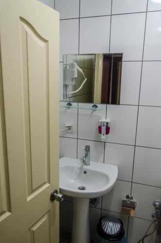 a bathroom with a white sink and a mirror at Çanakkale Venüs Pansiyon in Canakkale