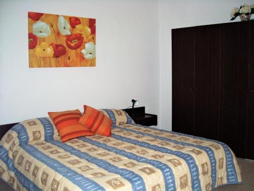 a bedroom with a bed with a painting on the wall at Alloggio Basilico in Diano San Pietro