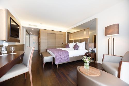 a hotel room with a bed and a living room at IMLAUER HOTEL PITTER Salzburg in Salzburg