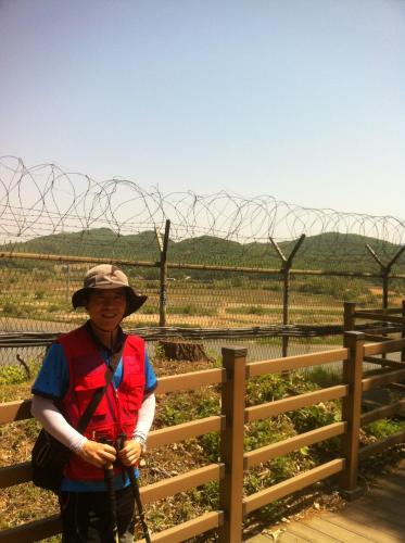 a woman standing in front of a barbed wire fence at The Guesthouse DMZ Stay in Paju