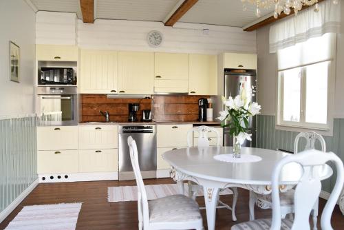 a kitchen with a white table and a table and chairs at Krepelin Apartments in Kristiinankaupunki