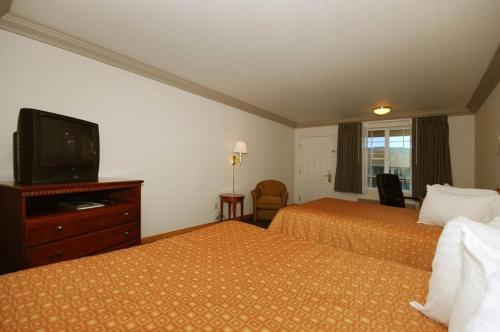 a hotel room with two beds and a flat screen tv at Cloverdale Wine Country Inn & Suites in Cloverdale