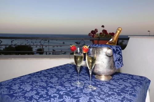 two glasses of wine on a table with a bottle of champagne at Punta Campanella Resort & Spa in Massa Lubrense