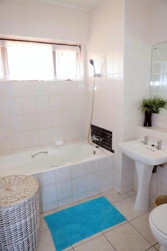 a white bathroom with a tub and a sink at Sea Wave Holidays - Stella Maris in Amanzimtoti