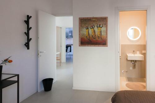 Jest to biały pokój z łazienką i umywalką. w obiekcie Flora Home w mieście Marina di Carrara