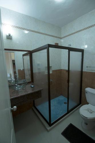 une salle de bain avec une douche avec des toilettes et un lavabo dans l'établissement Hotel Isleño, à Isla Mujeres