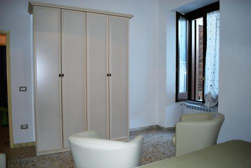 a room with white cabinets and two white chairs at La Mariposa in Nova Siri