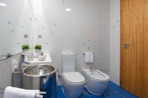 a bathroom with a toilet and a sink at Casas da Pescaria A in Nazaré