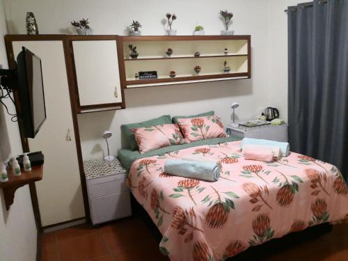 1 dormitorio con 1 cama con edredón rosa en Doedoe Plekkie, en Rustenburg