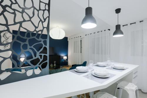 a white dining room with a white table and chairs at Naeva Feng Shui in Strasbourg