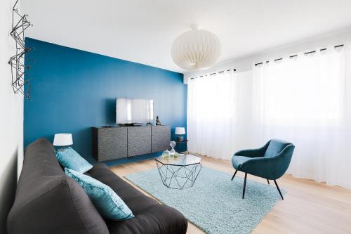 a living room with a brown couch and a blue wall at Naeva Feng Shui in Strasbourg
