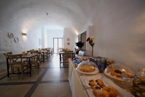 una habitación con mesas y sillas con comida a la vista en GH Dimora Sant'Anna, en Carovigno