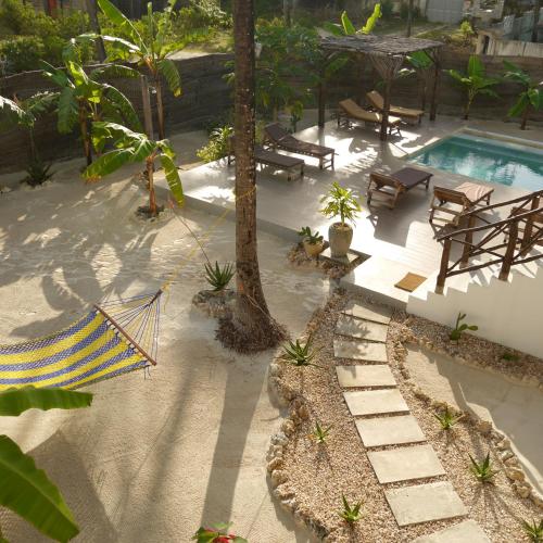 a backyard with a hammock and a swimming pool at Villa Huruma in Paje