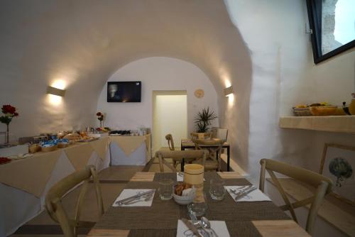 uma sala de jantar com mesa e cadeiras e uma cozinha em GH Dimora Sant'Anna em Carovigno