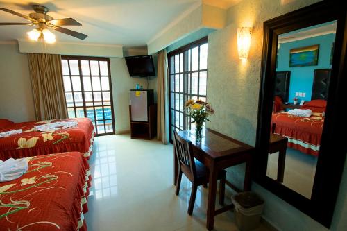 a hotel room with a bedroom with two beds and a table at Hotel Isleño in Isla Mujeres