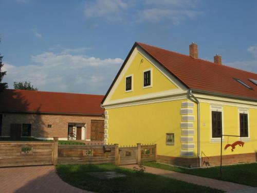 オリセントペーテルにあるFürge Róka Portaの木塀のある黄色い家