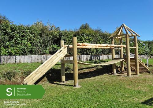 a wooden playground with a slide and a gazebo at Cabañas Amunantu in Futrono