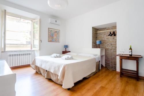 een witte slaapkamer met 2 bedden en een raam bij Monti Garden in Rome