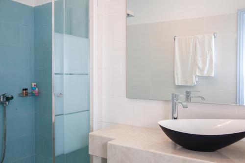 a bathroom with a sink and a glass shower at Luna Rossa Santorini in Imerovigli