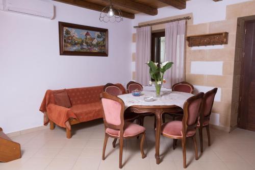 a dining room with a table and chairs and a couch at Irini's Home in Melissouryíon