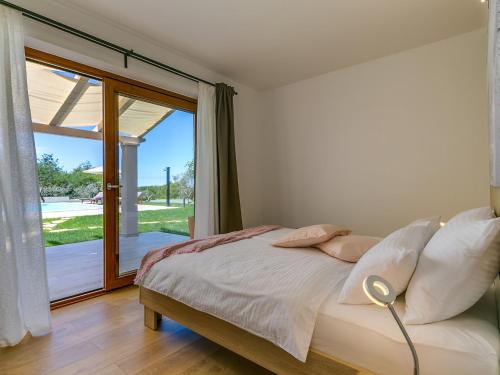 Schlafzimmer mit einem Bett und einer Glasschiebetür in der Unterkunft Pool Premium Apartment in Vrsar