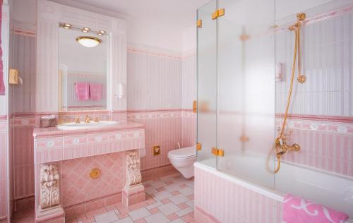 a pink bathroom with a sink and a toilet at Schlosshotel Römischer Kaiser in Vienna