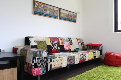 a colorful couch in a room with a green rug at Casa Viriato in Santa Maria Da Feira