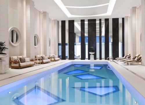 a large swimming pool with blue water in a room at Rosewood Hotel Georgia in Vancouver