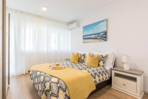 a bedroom with a bed with a yellow blanket at Relax & Recharge SEA VIEW Apartment in Split